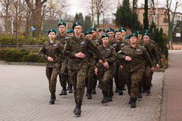Uczniowie w mundurach podczas musztry na placu szkolnym